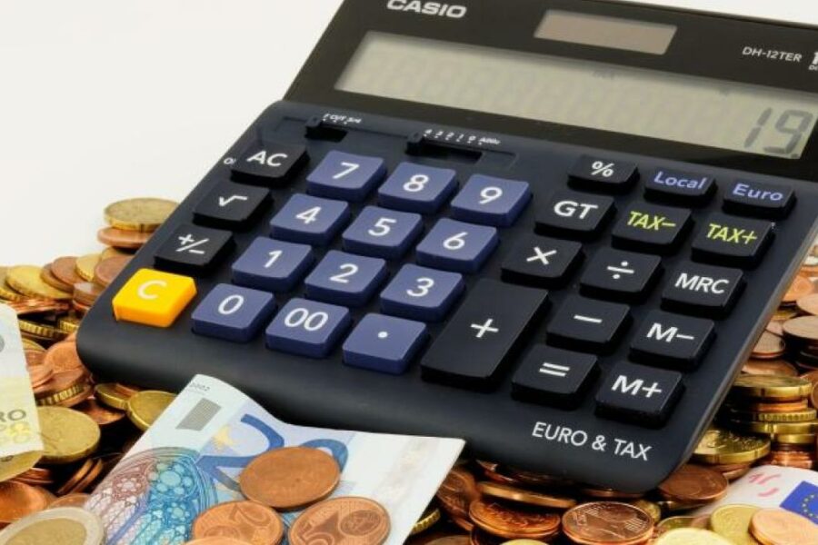 Calculator on euros and coins, financial calculation concept.
