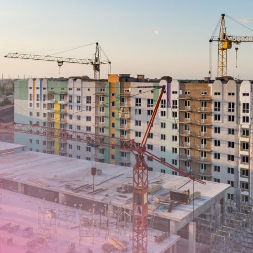 Urban construction site with cranes and high-rise buildings under development.