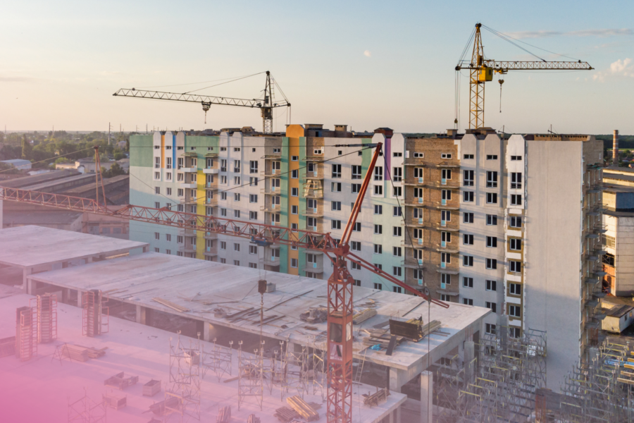 Urban construction site with cranes and high-rise buildings under development.