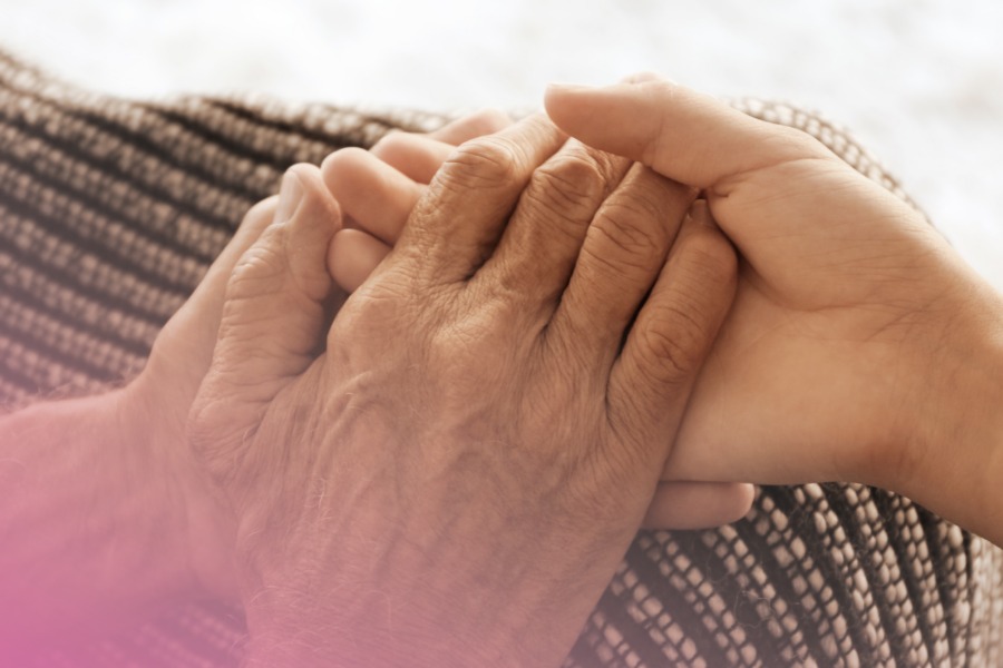 Holding an elderly lady's hands to symbol caring for their capacity