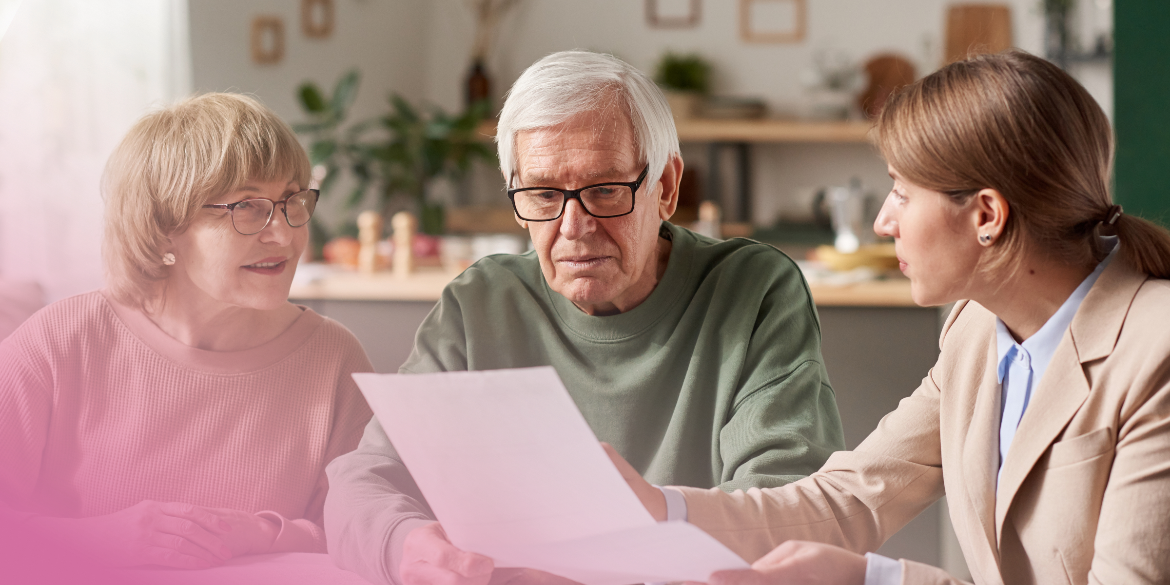 Elderly couple reviewing documents with a consultant in a cosy home setting.