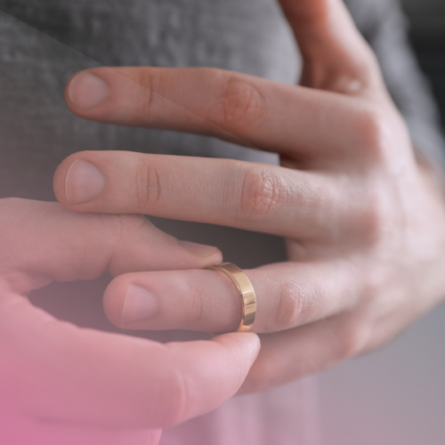 Person removing a gold wedding ring from finger.
