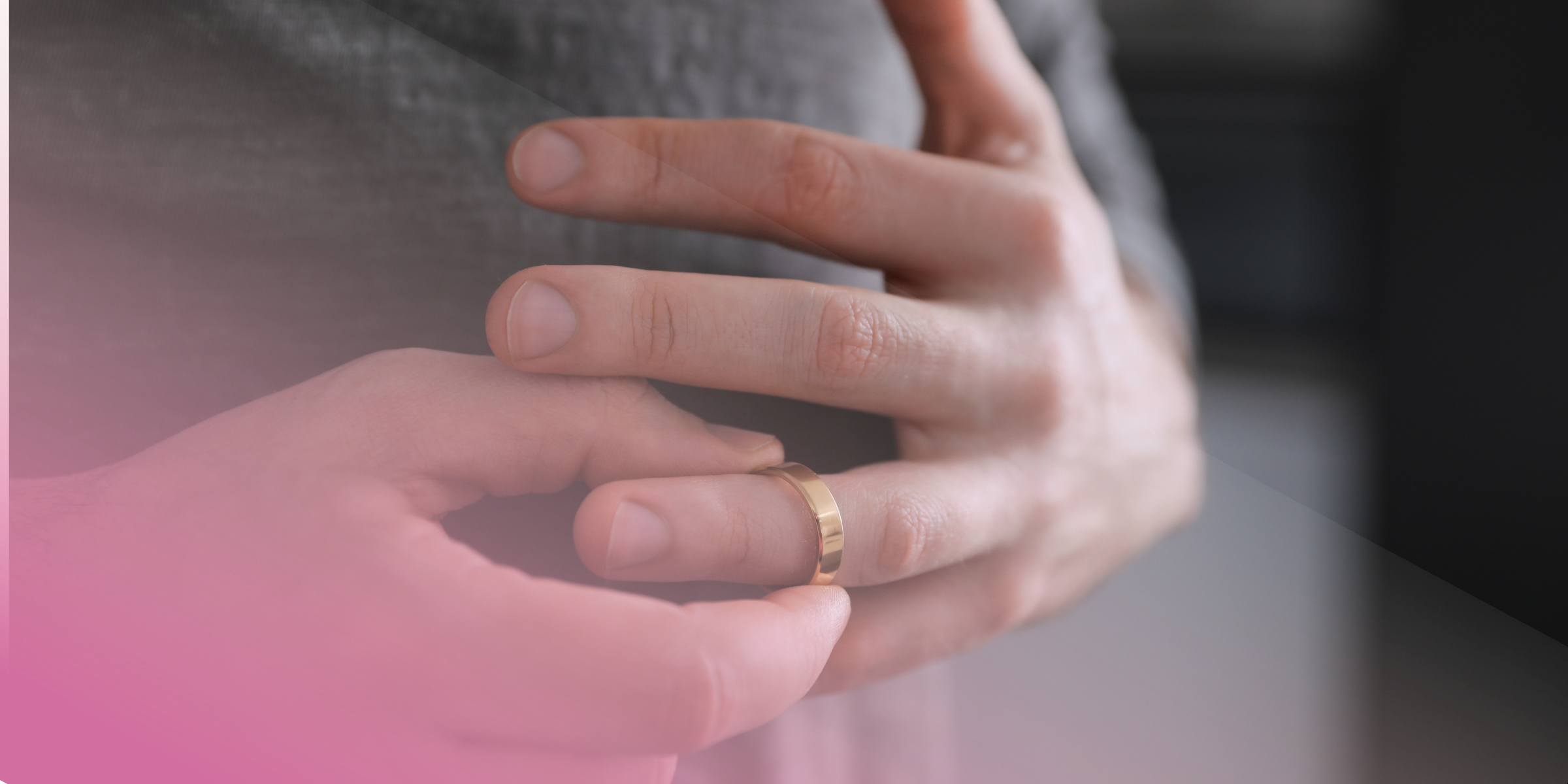 Person removing a gold wedding ring from finger.