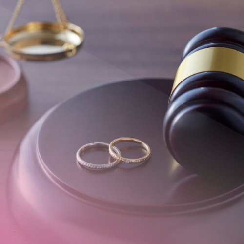 Gavel with wedding rings and scales, symbolising justice and marriage.