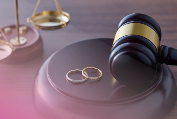 Gavel with wedding rings and scales, symbolising justice and marriage.