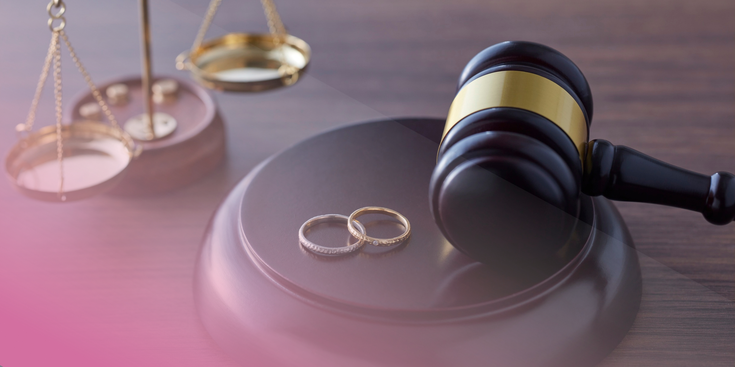 Gavel with wedding rings and scales, symbolising justice and marriage.