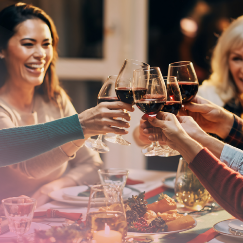 Friends toasting wine glasses at dinner party celebration