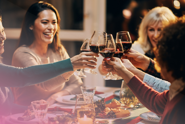 Friends toasting wine glasses at dinner party celebration