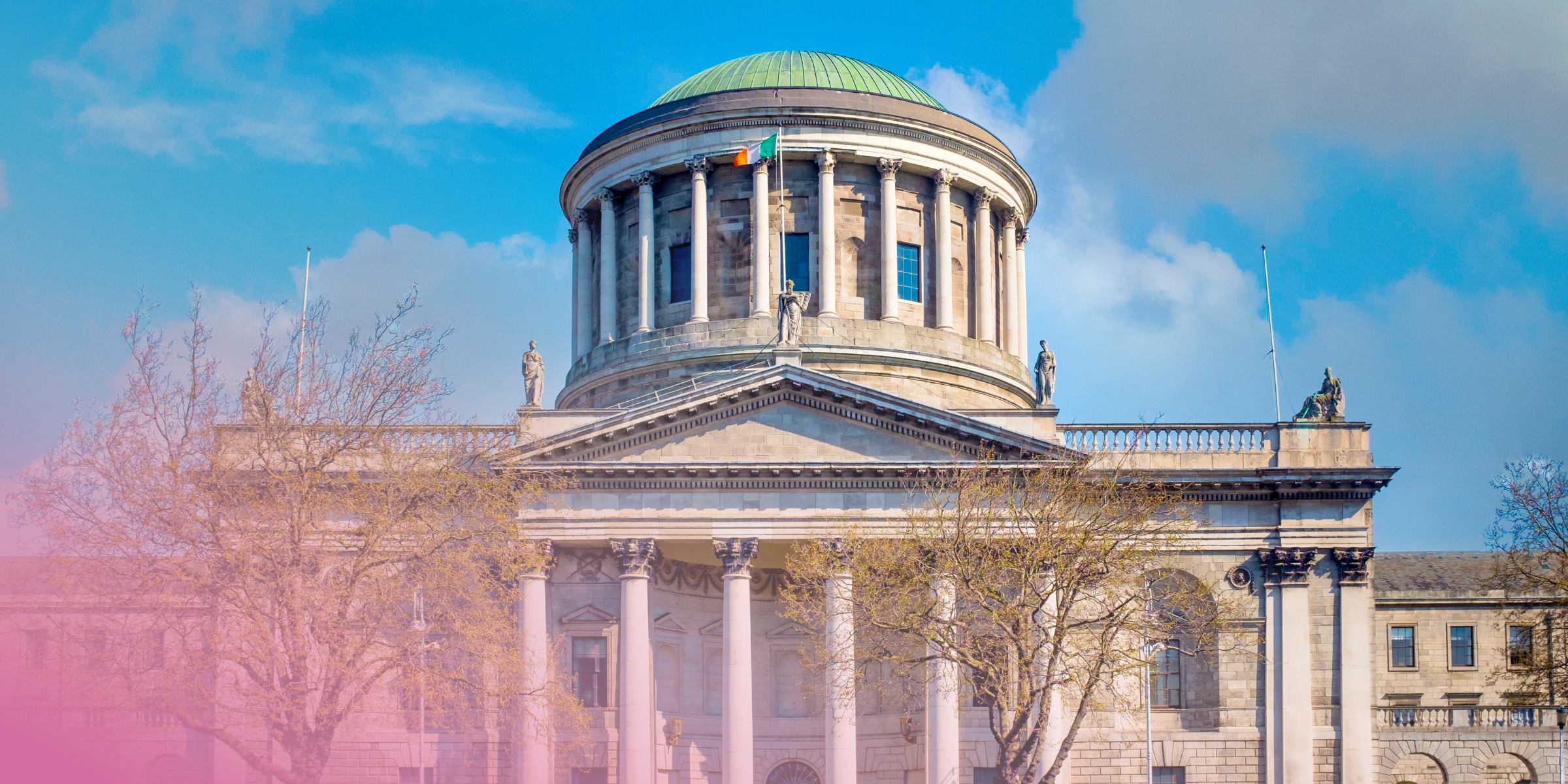 Historic courthouse with domed roof and columns under blue sky.