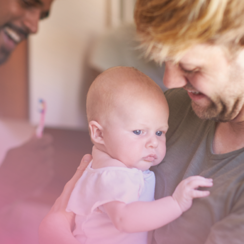 A happy family moment: smiling parents with their baby at home.