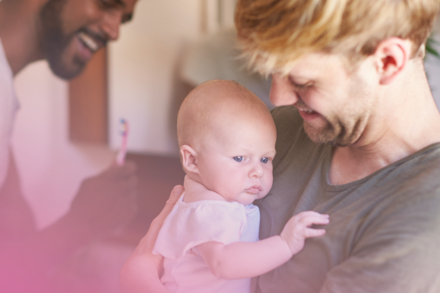 A happy family moment: smiling parents with their baby at home.