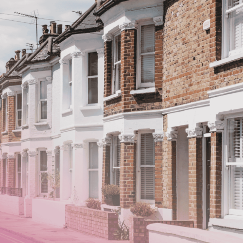 Row of traditional British terraced houses on a sunny street.