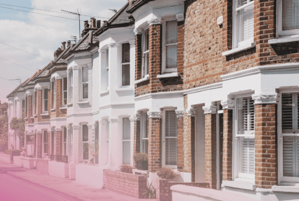 Row of traditional British terraced houses on a sunny street.