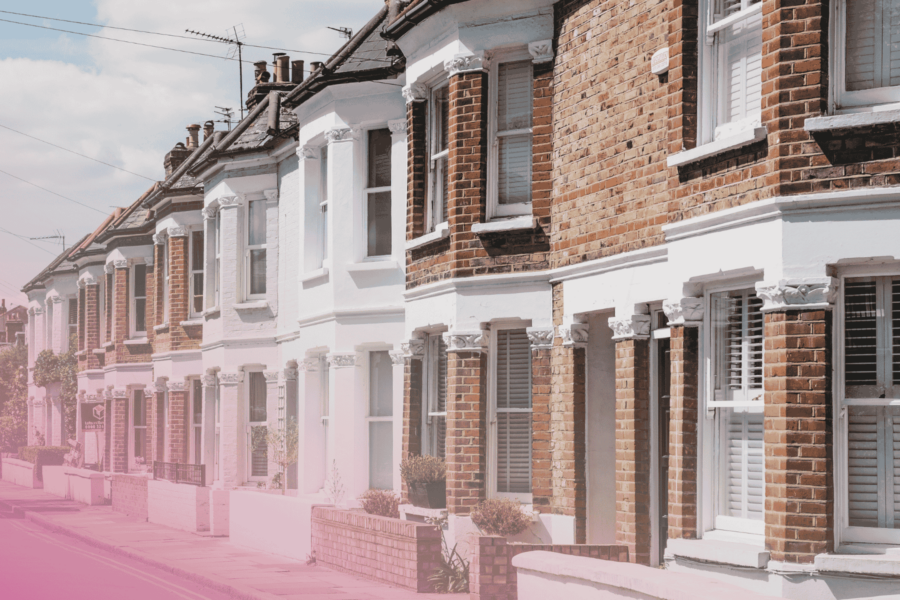 Row of traditional British terraced houses on a sunny street.