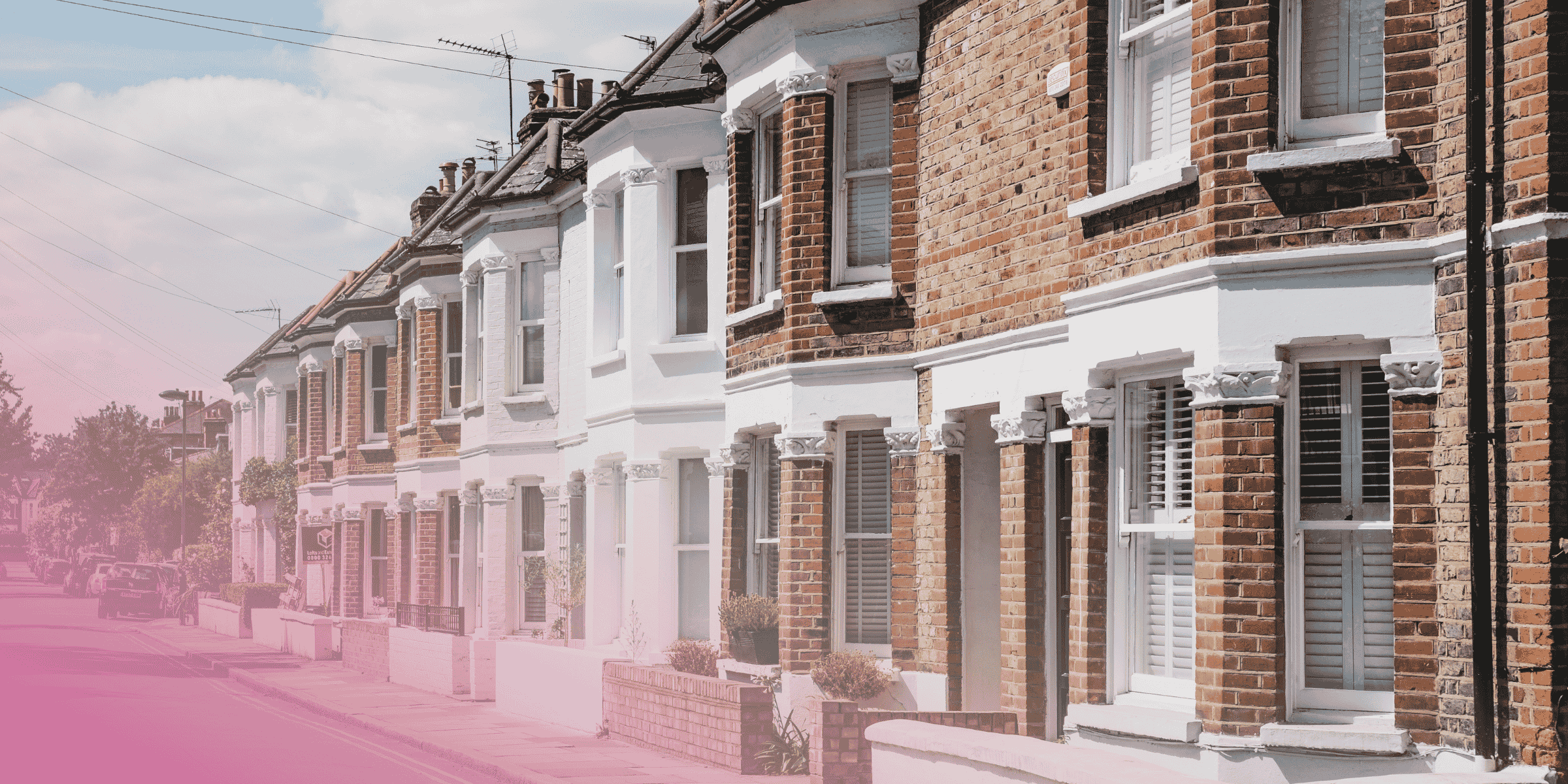 Row of traditional British terraced houses on a sunny street.